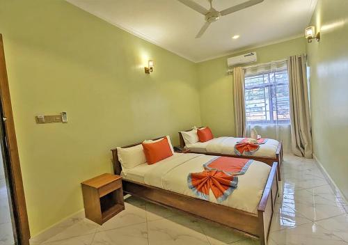a bedroom with two beds and a window at Salpat Camp Lodge in Moshi