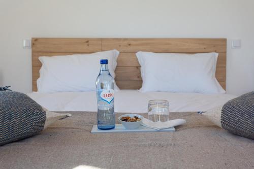 a bottle of water and a plate of food on a bed at Cerro da Campaniça in Santiago do Cacém