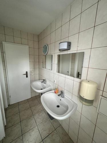 a bathroom with two sinks and a mirror at Pension Baron in Fürth
