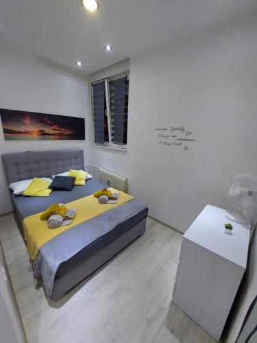 a bedroom with two beds and a table and a sign on the wall at Apartment Alex in Rijeka