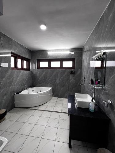 a large bathroom with a tub and a sink at Mandala Resorts & Events in Panepa