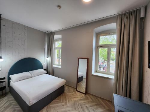 a bedroom with a bed and a mirror at Hotel Amfiteatar in Pula