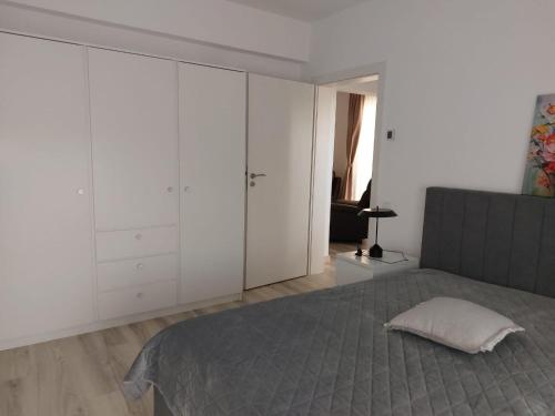a bedroom with white cabinets and a bed with a pillow at Romanescu Parc Apartment in Craiova