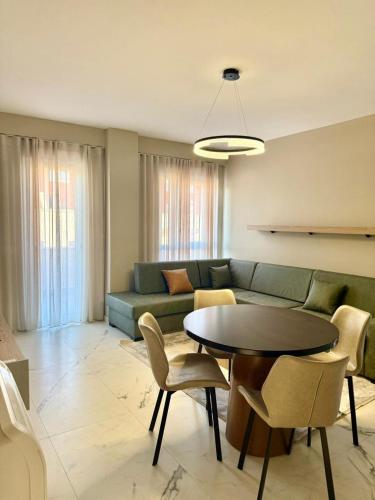 ein Wohnzimmer mit Sofa, Tisch und Stühlen in der Unterkunft M&I Apartment in Sarandë