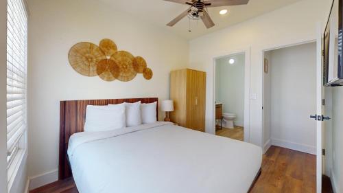 a bedroom with a white bed and a ceiling fan at The Beach House in Ocean City