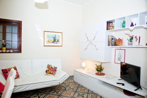 a living room with a white couch and a tv at La Casa di Baldo in Ugento