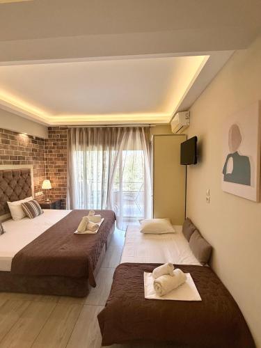 a hotel room with two beds and a window at Aroma Villa & Studios in Limenas