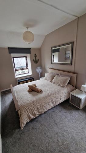 a bedroom with a large bed and a mirror at Penbryn Holidays, Barmouth in Barmouth