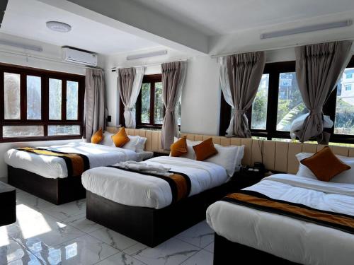 three beds in a room with windows at Mandala Resorts & Events in Panepa