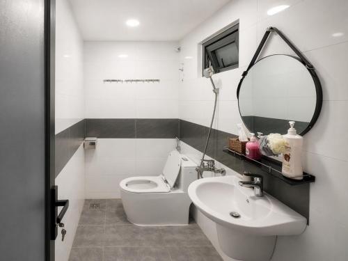 a bathroom with a toilet and a sink and a mirror at Happy Life Hotel DaLat in Da Lat