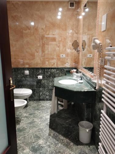 a bathroom with a sink and a toilet at Ermitage Bel Air Medical Hotel in Abano Terme
