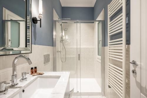 a bathroom with a shower and a sink and a mirror at Brunelleschi Prestige by MMega in Florence