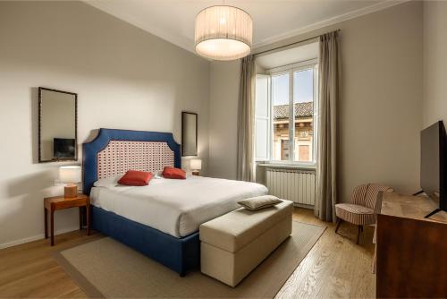 a bedroom with a bed and a chair and a television at Brunelleschi Prestige by MMega in Florence