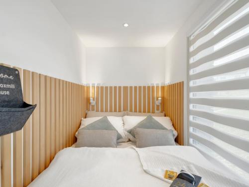 a bedroom with a white bed with pillows at Stilvolles Design-Tiny-House mit Terrasse & Hund in Fuchsmühl