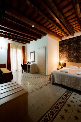 a bedroom with a bed and a desk in a room at Porta delle Botteghelle in Trapani