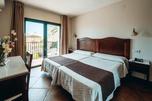 a bedroom with a large bed and a large window at Arcos de Montemar in Torremolinos