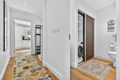 a white bathroom with a washer and dryer in it at Cnoc Na RI in Strandhill