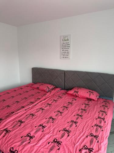 a bed with a pink bedspread with black spiders on it at Villa Violand 2 in Limanu