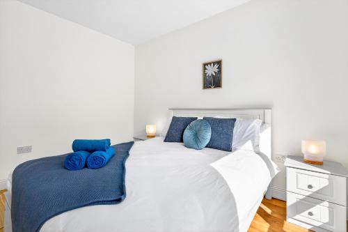a bedroom with a white bed with blue pillows at Cnoc Na RI in Strandhill