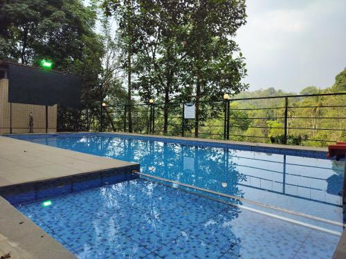a swimming pool with blue water and a fence at Riva Resorts in Vythiri