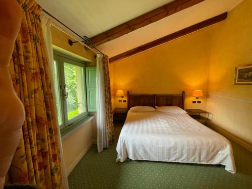 a bedroom with a white bed and a window at Locanda Maison Verte in Cantalupa