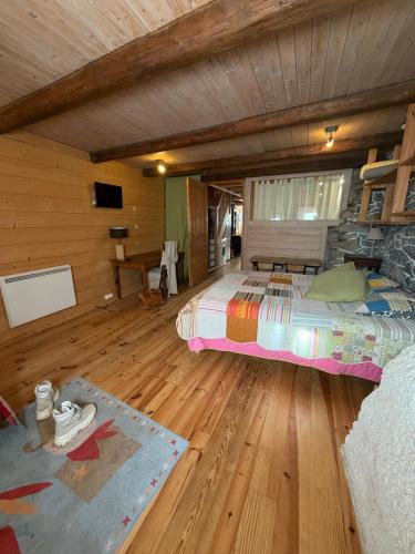 a bedroom with a bed and a wooden floor at La Marguerite in Aigueblanche