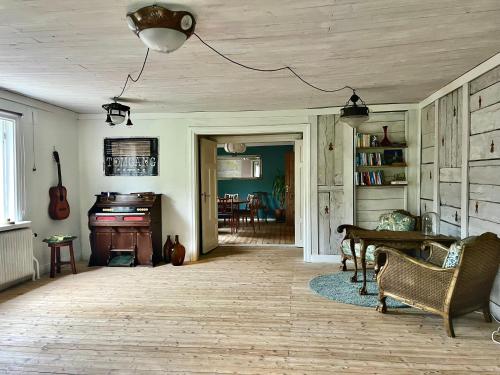 a living room with a table and a piano at Visseltofta old café - unexpected and picturesque in Osby
