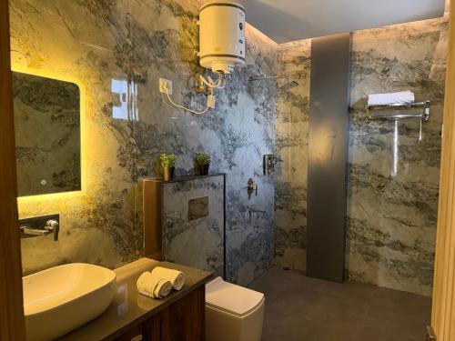 a bathroom with a sink and a toilet and a shower at Hotel Savaya Luxury Stay Near AIIMS Rishikesh in Rishīkesh