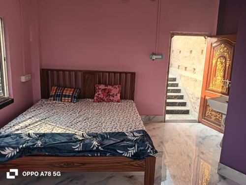 a bedroom with a bed in a purple wall at Mohana Homestay in Tāki