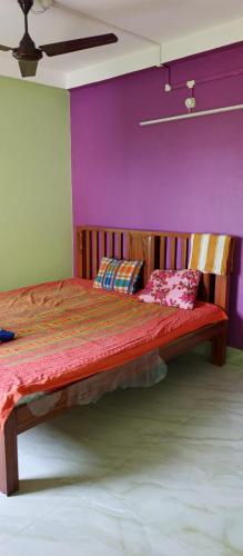 a bedroom with a bed with a purple wall at Mohana Homestay in Tāki