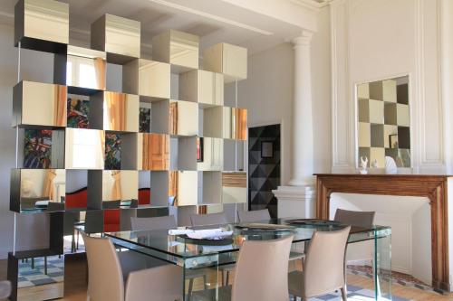 una sala da pranzo con tavolo in vetro e sedie di L'Hôtel Particulier Guilhon a Lectoure