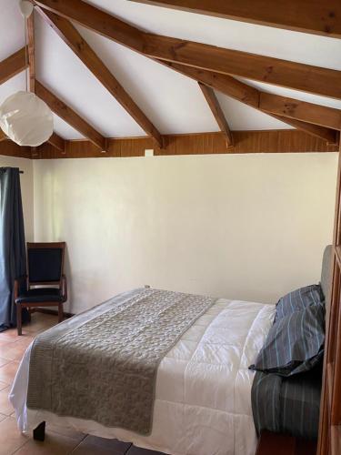 a bedroom with a bed and a chair at Elqui LU ASPAR in Vicuña