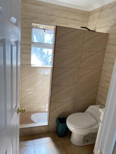 a bathroom with a toilet and a window at Elqui LU ASPAR in Vicuña