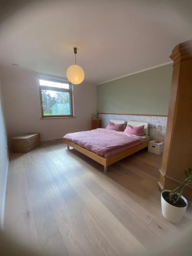 a bedroom with a bed with pink sheets and a window at Meyer im Moor in Grasberg