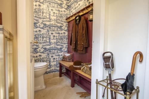 a bathroom with a toilet and blue and white wallpaper at Virginia Cottage in York