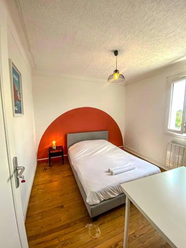 a small bedroom with a bed and a table at TiArMor Saint-Brieuc Ville in Saint-Brieuc
