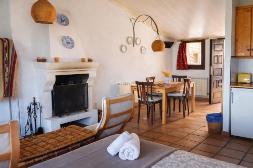 a living room with a table and a fireplace at Loft con chimenea y terraza con vistas - Cal Caterino in Montsonis