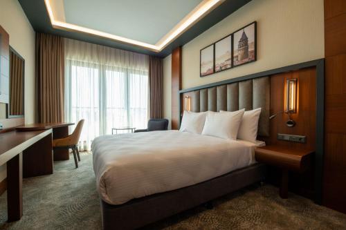 a hotel room with a bed and a desk at TRYP by Wyndham Istanbul Maltepe in Istanbul