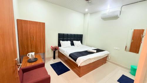 a bedroom with a bed and a wooden cabinet at Hotel Blessing Inn & Restaurant in Prayagraj