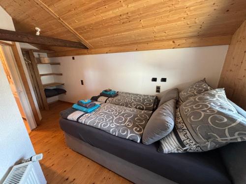 a large bed in a room with a wooden ceiling at Tiny House mit Garten und Sauna in Karbach