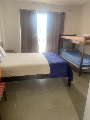 a bedroom with two bunk beds and a window at Casa surf in Guaratuba