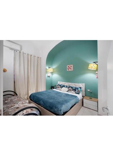 a bedroom with two beds and a blue wall at Casetta FRM home in Naples