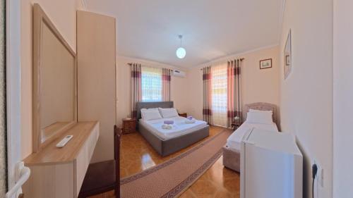 a room with two beds and a couch in it at Apartment Darlin Berat in Berat