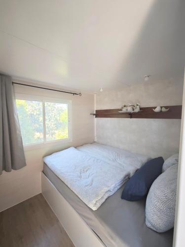 a bed in a small room with a window at Casa Azul-Tiny house with fantastic view, big outdoor space and pool in Silves