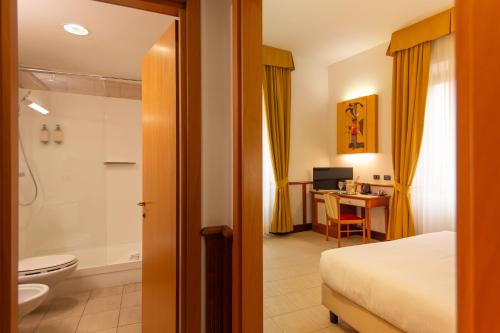 a hotel room with a bathroom with a bed and a shower at Hotel Duomo - Etruria Collection in Orvieto