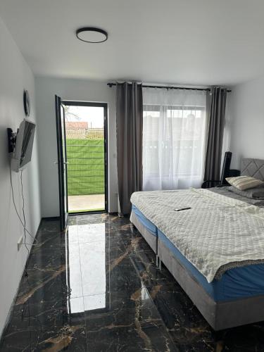 a bedroom with a bed and a sliding glass door at Villa Violand 3 in Limanu