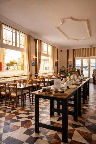 a restaurant with tables and chairs and windows at LOGIS Hotel Majestic Chatelaillon Plage - La Rochelle in Châtelaillon-Plage