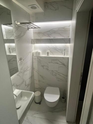 a white bathroom with a toilet and a sink at Sarti Paradise in Sarti