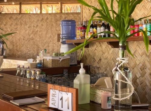 Eine Bar mit einer Pflanze in einer Vase auf dem Tresen in der Unterkunft Camp Laya Daracoton Island in El Nido