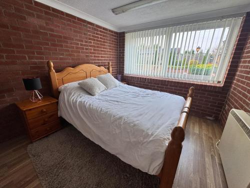 a bedroom with a bed and a brick wall at The pool house in Bedford